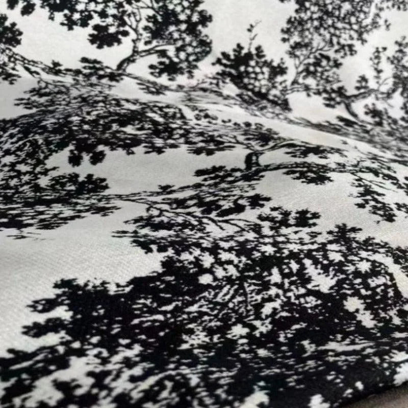 Image d'un tissu imprimé avec un motif détaillé de paysage naturel en noir et blanc. Design élégant et sophistiqué, idéal pour la décoration intérieure, apportant une touche artistique et moderne à votre espace. Parfait pour habiller coussins ou rideaux et ajouter du caractère à chaque pièce.