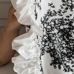 Blouse élégante avec imprimé noir et blanc, ornée de volants raffinés sur le côté, idéale pour un style chic et moderne. Ce vêtement est parfait pour rehausser votre garde-robe avec une touche de sophistication sans effort.