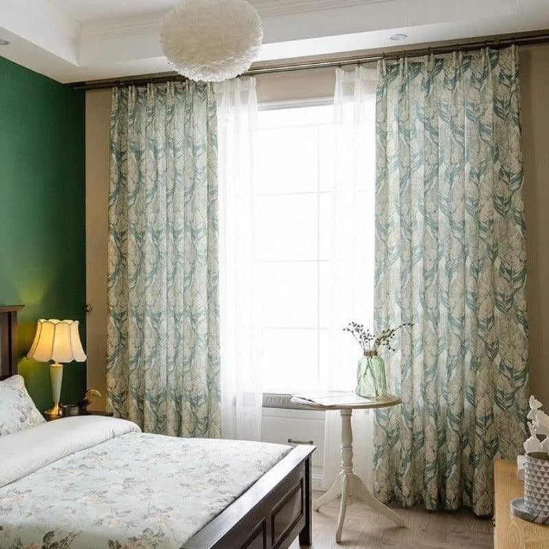 Chambre élégante avec rideaux imprimés à motifs végétaux, créant une ambiance apaisante. Fenêtre lumineuse encadrée par des rideaux longs, ajoutant une touche de sophistication à la décoration intérieure. Ajout parfait pour une chambre moderne et accueillante.