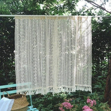Rideau élégant suspendu dans un jardin fleuri, parfait pour créer une ambiance naturelle et apaisante. Idéal pour décorer une terrasse ou un espace extérieur avec style. Accessoire décoratif qui filtre doucement la lumière tout en préservant l'intimité.