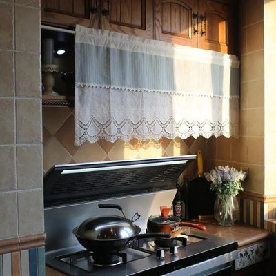 Petit rideau de cuisine suspendu, offrant une touche décorative élégante et classique. Ce rideau court sert à embellir la fenêtre au-dessus du plan de cuisson, ajoutant une ambiance chaleureuse et accueillante à l'espace culinaire. Idéal pour filtrer la lumière tout en préservant l'intimité, ce rideau rehausse l'esthétique de votre cuisine. Parfait pour un intérieur traditionnel ou contemporain.