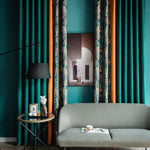 Salon moderne avec rideaux élégants dans des tons turquoise et orange, complété par un canapé gris stylé. Décoration intérieure chic avec une lampe sophistiquée et une table d'appoint contemporaine, idéale pour un espace de vie raffiné et accueillant.