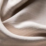 Texture douce d'un tissu beige, parfaite pour une décoration intérieure élégante. Cette image met en avant la subtilité des nuances qui créent une ambiance chaleureuse et accueillante. Le design du tissu offre une esthétique moderne et raffinée, idéale pour des coussins, rideaux ou autres éléments décoratifs.