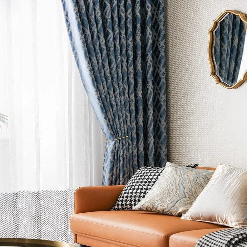 Canapé moderne orange avec coussins décoratifs élégants. Rideaux bleus à motifs installés près d'une fenêtre pour un style intérieur raffiné. Miroir mural au design sophistiqué. Ambiance chaleureuse et chic pour salon contemporain. Décoration intérieure inspirante et harmonieuse.