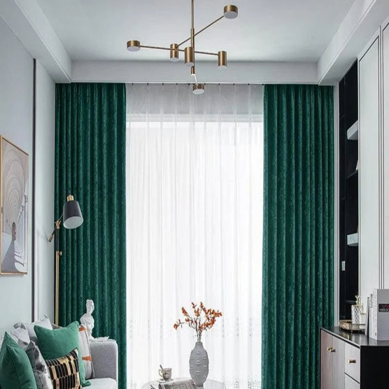 Salon élégant avec rideaux verts et lampadaire moderne. Canapé confortable orné de coussins colorés, table basse avec vase décoratif. Luminaire suspendu stylé, combinant design contemporain et douceur naturelle. Idéal pour une décoration intérieure harmonieuse. Parfait pour créer une ambiance chaleureuse et accueillante dans un espace de vie raffiné.