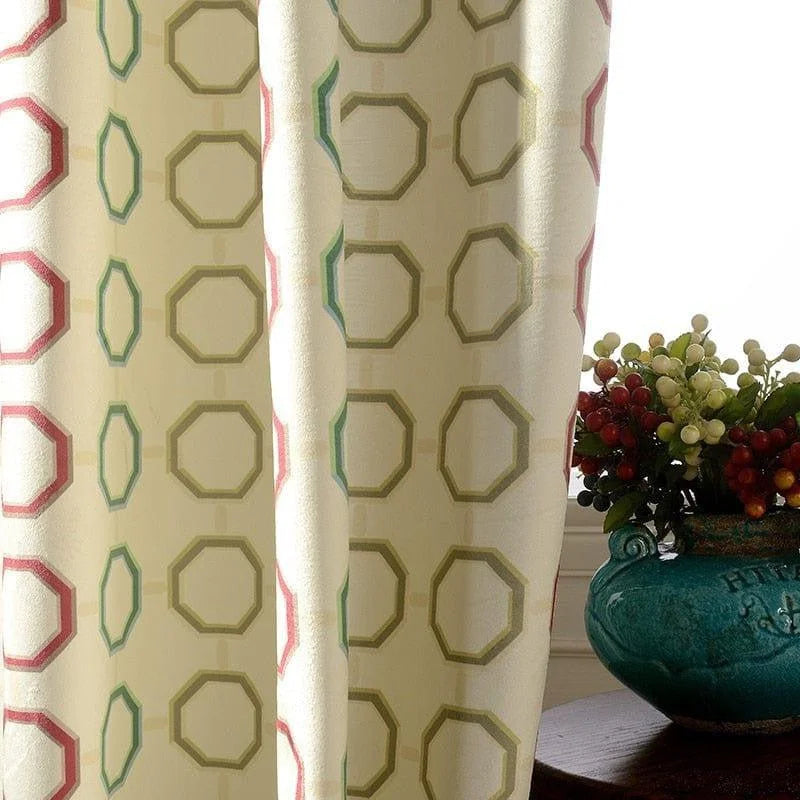 Rideau élégant avec motif géométrique octogonal multicolore, parfait pour ajouter une touche moderne à votre intérieur. Accessoire décoratif idéal pour le salon ou la chambre, combinant esthétique et fonctionnalité. Différents tons de rouge, vert et beige apportent une ambiance chaleureuse et accueillante à votre espace. Le vase et les baies décoratives complètent harmonieusement la composition.