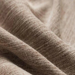 Texture de tissu beige en gros plan, montrant des motifs subtils et des ondulations délicates. Parfait pour l'ameublement ou les vêtements, ce tissu polyvalent offre une allure élégante et naturelle, idéale pour une décoration ou une mode intemporelle.