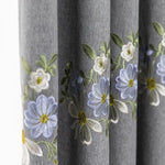 Rideau gris avec broderies florales bleues et blanches, motif élégant pour décoration intérieure, accessoire maison tendance pour salon ou chambre, design raffiné et moderne.