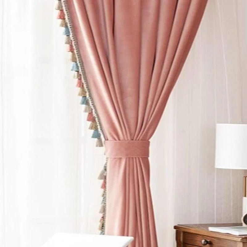 Rideau élégant de couleur rose avec embrasse décorative, doté de bordures à pompons multicolores. Idéal pour ajouter une touche chic et sophistiquée à votre salon ou chambre. S'intègre parfaitement dans un décor moderne ou classique avec mobilier en bois. Accessoire décoratif parfait pour rehausser l'ambiance de votre intérieur tout en offrant une belle luminosité à la pièce.