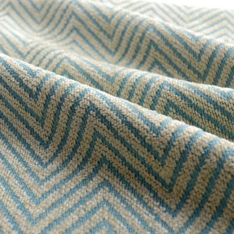 Tissu avec motif à chevrons de couleur bleue et beige, idéal pour la décoration intérieure ou la création de vêtements stylés, avec un allure moderne et élégante.