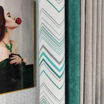 Rideaux modernes aux motifs géométriques, avec un design élégant en chevron, combinant des teintes de turquoise, gris et vert. Parfait pour ajouter une touche artistique à votre intérieur, ces rideaux sont présentés à côté d'une œuvre d'art vibrante, créant un contraste chic et raffiné dans votre salon. Idéal pour ceux qui cherchent à harmoniser décoration artistique et fonctionnalité dans leur espace de vie.