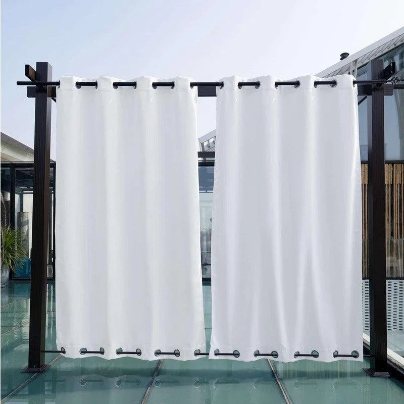 Rideaux occultants blancs suspendus à une structure extérieure moderne, idéaux pour créer un espace privé sur une terrasse ou dans un jardin. Parfaits pour bloquer la lumière du soleil tout en ajoutant une touche élégante à votre espace extérieur.
