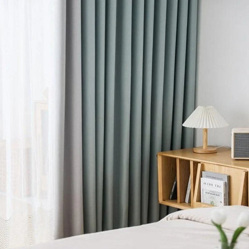 Rideaux d'intérieur élégants et modernes dans une chambre lumineuse avec table de chevet en bois, lampe design et éléments de décoration minimalistes. Idéal pour créer une ambiance apaisante et contemporaine.