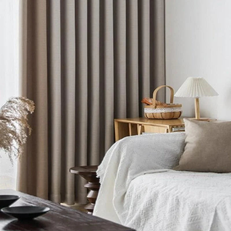 Rideaux élégants de couleur neutre dans un salon moderne avec canapé blanc et coussins, décor accueillant et lumineux mettant en valeur une ambiance chaleureuse et apaisante. Parfait pour une décoration d'intérieur contemporaine.