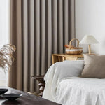 Rideaux élégants de couleur neutre dans un salon moderne avec canapé blanc et coussins, décor accueillant et lumineux mettant en valeur une ambiance chaleureuse et apaisante. Parfait pour une décoration d'intérieur contemporaine.