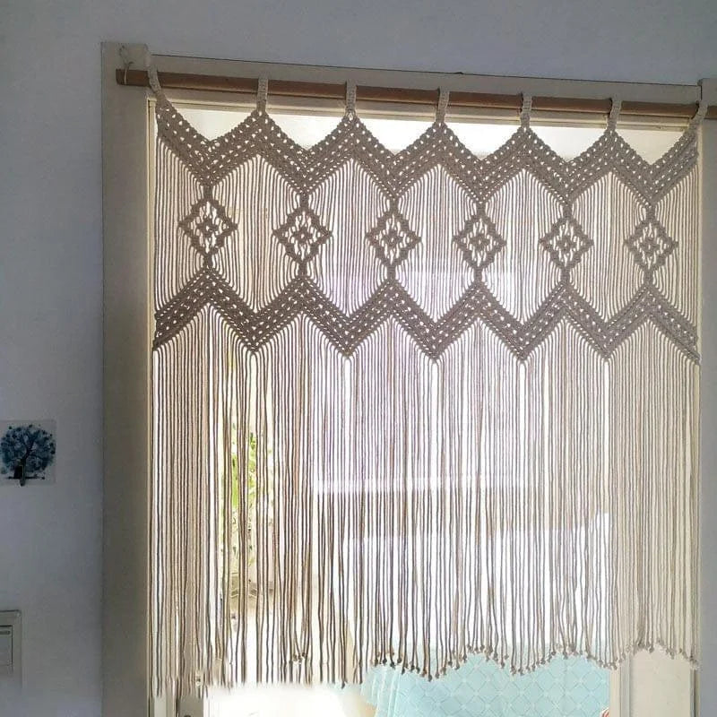Rideau en macramé suspendu devant une fenêtre, ajoutant une touche bohème et décorative à la pièce. Les motifs géométriques et les franges créent une ambiance chaleureuse et accueillante, idéale pour la décoration intérieure. Convient parfaitement pour des espaces lumineux et naturels.