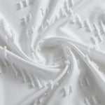 Image d’un tissu élégant de couleur blanche, présentant une texture douce et des motifs légèrement en relief. Idéal pour la décoration intérieure ou la confection de vêtements sophistiqués, ajoutant une touche de raffinement et de modernité.