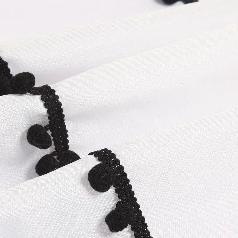 Rideau blanc avec détail de bordure à pompons noirs, design élégant et moderne pour ajouter une touche unique à votre décoration intérieure. Idéal pour les salons, chambres, et espaces de vie, ce rideau offre un style distinctif et sophistiqué.