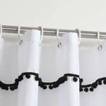 Rideau de douche blanc avec franges décoratives noires, suspendu à une tringle en métal argenté. Accessoire de salle de bain moderne ajoutant une touche élégante et contrastée à votre décoration intérieure. Facile à installer avec des anneaux de suspension inclus, idéal pour embellir votre espace de douche.