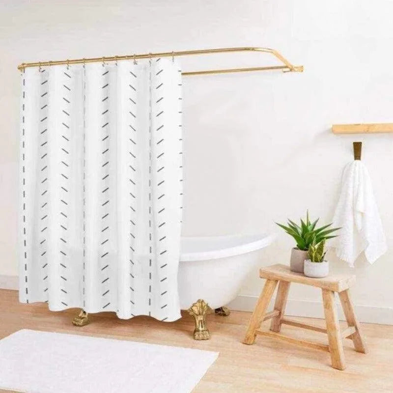Rideau de douche moderne avec motif géométrique noir sur fond blanc, installé dans une salle de bain élégante avec baignoire sur pieds dorés. Complété par une décoration naturelle, une plante verte sur un tabouret en bois, et une serviette blanche suspendue. Idéal pour ajouter une touche de style contemporain à votre espace.