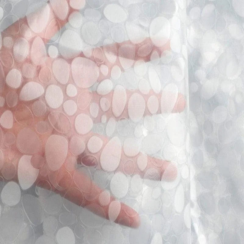 Main visible à travers un rideau translucide avec motifs ovales. Idéal pour une décoration intérieure moderne et élégante, ce rideau offre une luminosité douce tout en préservant l’intimité. Parfait pour chambres ou salons, il s'adapte à tout type de fenêtre.