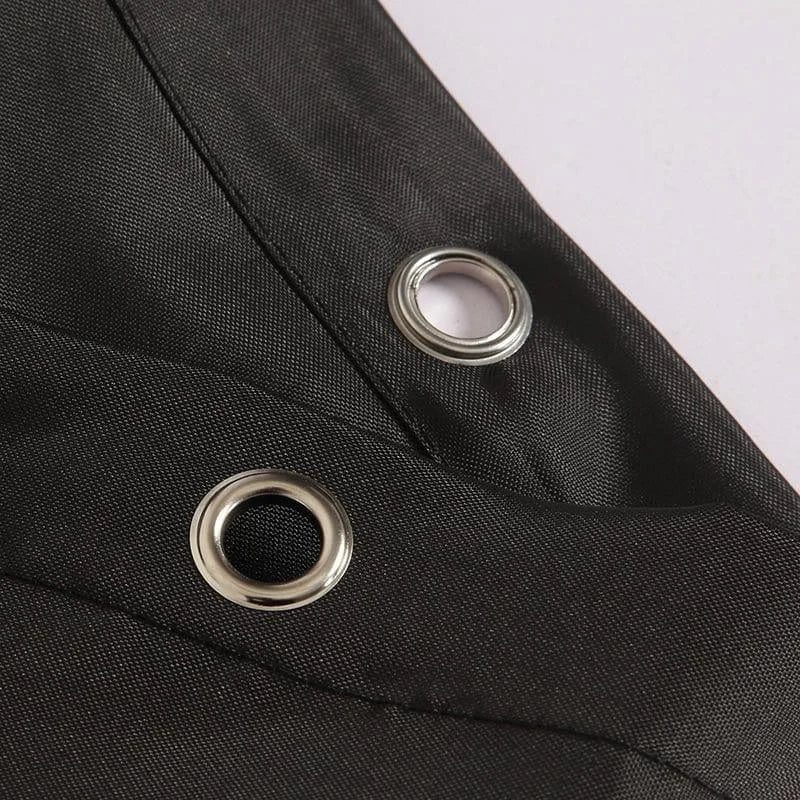 Gros plan sur un tissu noir avec des œillets métalliques. Accessoire idéal pour renforcer et personnaliser vos créations textiles. Design élégant et moderne, parfait pour les projets de couture et de décoration. Ajustement facile et durable pour une utilisation quotidienne.