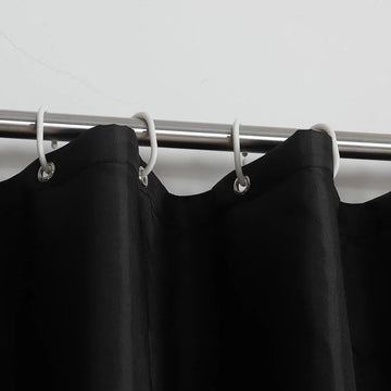 Rideau noir élégant accroché à une tringle métallique avec des anneaux blancs, idéal pour ajouter une touche moderne et sophistiquée à votre intérieur. Accessoire parfait pour la décoration de la maison, convenant aussi bien aux salons qu’aux chambres à coucher.