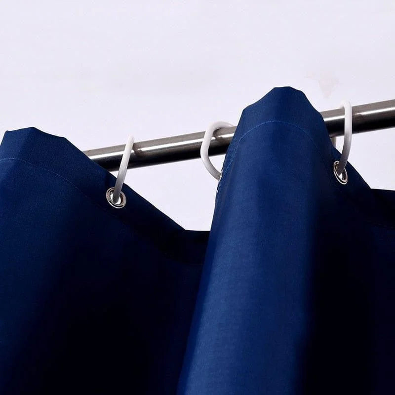 Rideau de douche bleu élégant suspendu à une barre métallique avec anneaux, idéal pour une salle de bain moderne et raffinée. Solution pratique pour préserver l'intimité tout en ajoutant une touche de style.