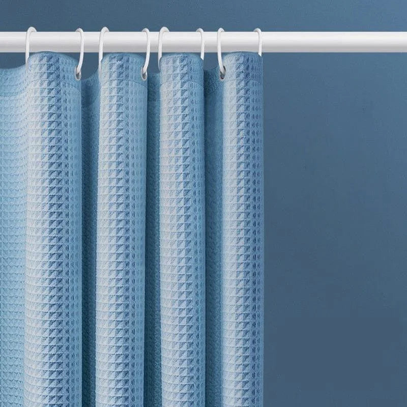 Rideau de douche bleu moderne avec motif texturé, idéal pour une salle de bain contemporaine. Dispose d'anneaux blancs assortis pour une fixation facile sur la tringle. Élément de décoration fonctionnel pour protéger des éclaboussures tout en ajoutant du style à votre espace.