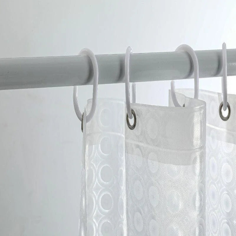 Barre de douche avec rideau transparent à motifs circulaires, suspendu par des anneaux blancs. Parfait pour une salle de bain moderne, alliant esthétique et fonctionnalité. Accessoire essentiel pour protéger des éclaboussures tout en apportant une touche de style élégant.