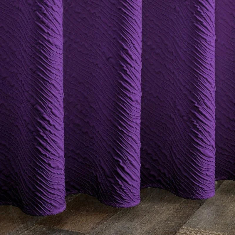 Rideau texturé violet déplié sur sol en bois, ajout contemporain et élégant pour la décoration intérieure, idéal pour salon ou chambre.