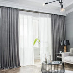 Rideaux modernes gris et blancs dans un salon élégant, style contemporain avec parquet en bois clair, table basse design et lampadaire noir, ambiance lumineuse et apaisante.