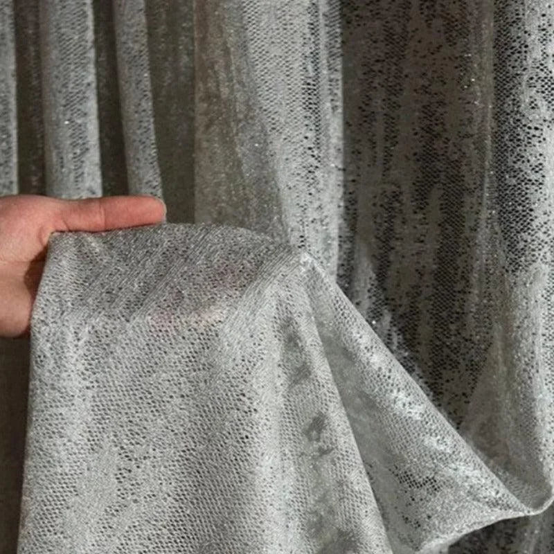 Rideau élégant argenté avec effet scintillant, parfait pour une décoration intérieure moderne et sophistiquée. Idéal pour ajouter une touche de glamour à tout espace de vie. Facile à intégrer dans différents styles d'intérieur, offrant à la fois intimité et lumière tamisée.
