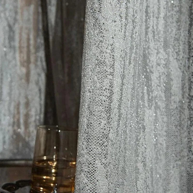 Rideau élégant gris légèrement scintillant pour intérieur moderne, idéal pour ajouter une touche de sophistication à votre salon ou chambre à coucher. Convient parfaitement pour filtrer la lumière tout en préservant l'intimité. Design subtil et chic pour sublimer votre décoration d'intérieur.