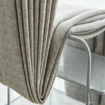 Couverture beige élégante posée sur une chaise moderne en métal, parfaite pour ajouter une touche de sophistication à votre salon ou chambre à coucher.
