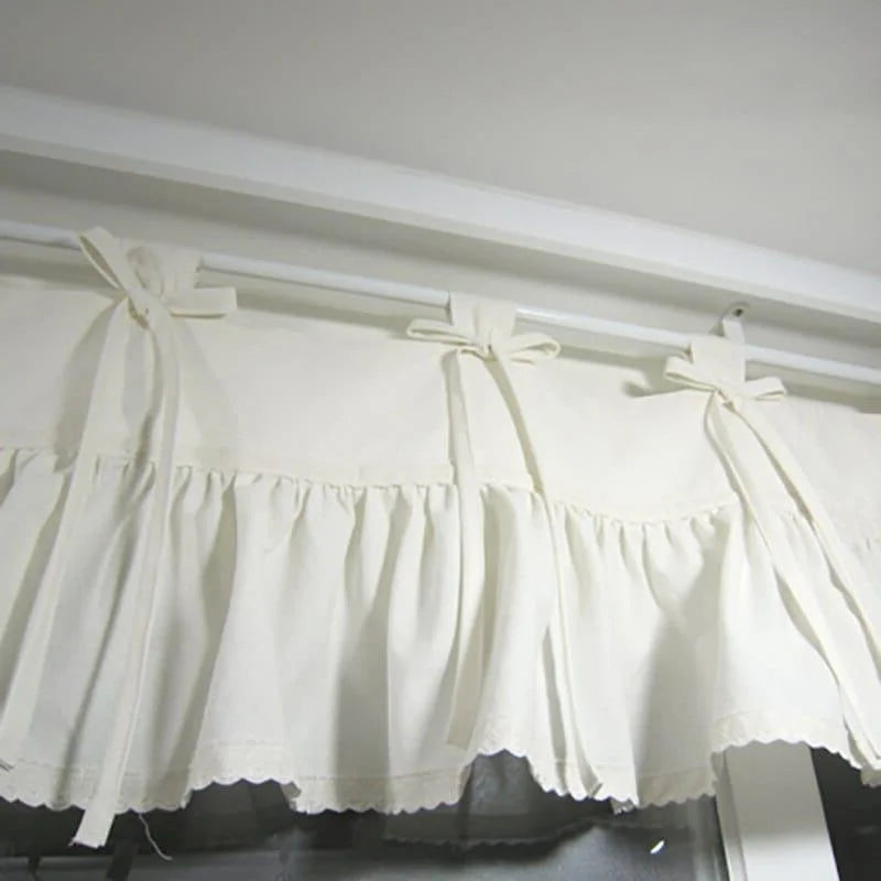 Cantonnière élégante et décorative pour fenêtre, avec volants et attaches en ruban, ajoutant une touche raffinée et romantique à tout intérieur. Conçue pour s'adapter facilement à une variété de tringles de rideaux, cette cantonnière blanche est idéale pour apporter luminosité et charme à vos espaces de vie. Parfaite pour les cuisines, salons ou chambres, elle combine fonctionnalité et esthétique.