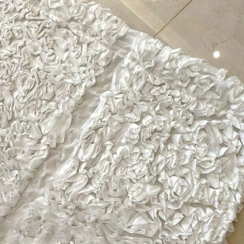 Tissu décoratif blanc avec un motif floral plissé, idéal pour les événements élégants et les décorations de mariage. Son design sophistiqué apporte une touche raffinée à toute ambiance, parfait pour créer une atmosphère lumineuse et apaisante.
