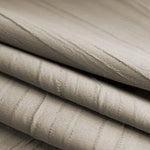 Empilement de tissu beige plissé avec motif subtil, idéal pour la décoration intérieure ou l'ameublement. Parfait pour apporter une touche d'élégance et de douceur à votre espace de vie.