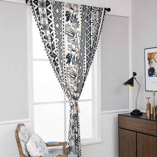 Rideau élégant avec motifs géométriques et floraux en noir et blanc, installé dans un salon moderne. Ce rideau ajoute une touche décorative sophistiquée à la pièce, créant un contraste visuel attrayant. Parfait pour sublimer votre espace de vie, il s'intègre harmonieusement avec divers styles de décoration intérieure, rehaussant l'ambiance lumineuse et contemporaine de votre maison.