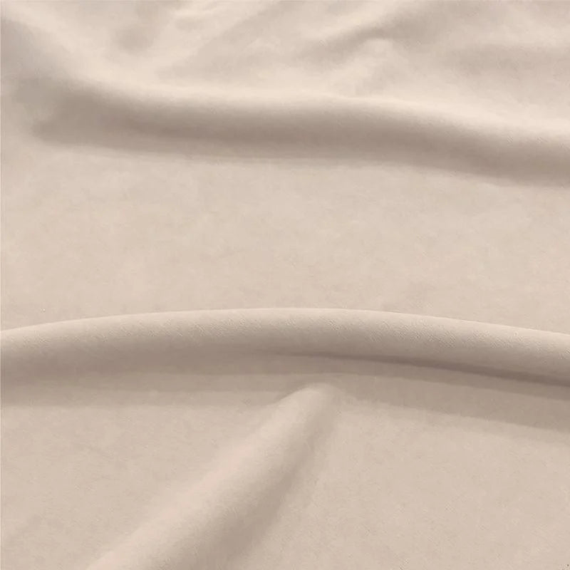 Image d'un tissu beige doux et élégant, idéal pour la confection de vêtements modernes et confortables. Ce textile présente une texture lisse, parfaite pour créer des tenues raffinées et sophistiquées. Parfait pour les projets de couture à domicile ou professionnels.
