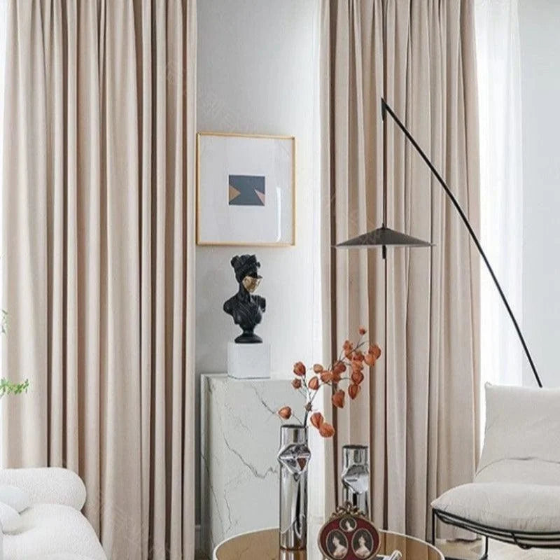 Rideaux élégants couleur beige ajoutant une touche moderne et raffinée à un salon contemporain, accompagnés de décorations artistiques et de meubles design pour un intérieur tendance et harmonieux.