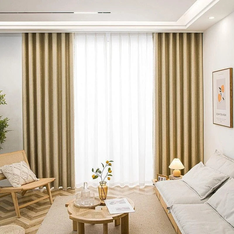 Salon moderne et accueillant avec rideaux élégants créant une ambiance chaleureuse. Le mobilier épuré et la décoration minimaliste ajoutent une touche de sophistication. Parfait pour un intérieur contemporain, combinant confort et style. Aménagement idéal pour optimiser la lumière naturelle et créer une atmosphère apaisante.