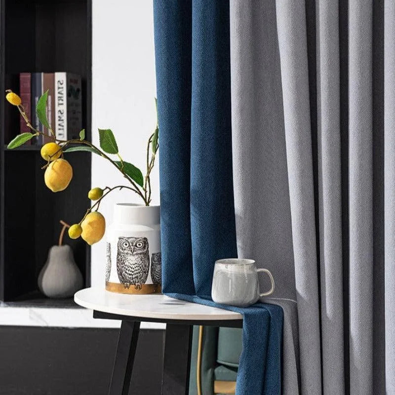 Rideaux élégants bleu et gris dans un salon moderne avec une décoration de vase à motif hibou et branche de citrons jaunes ajoutant une touche naturelle. Parfait pour sublimer l'intérieur de votre maison avec style et raffinement.