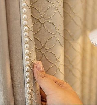 Rideau luxueux beige avec motif géométrique, agrémenté de perles décoratives sur le bord. Design élégant idéal pour embellir les intérieurs sophistiqués et contemporains. Solution parfaite pour ajouter une touche de glamour à votre salon ou chambre.
