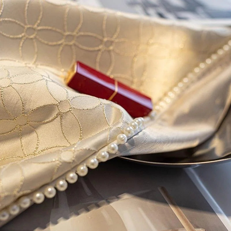 Élégant tissu brodé avec motifs géométriques et décoration perles, accompagné d'un rouge à lèvres rouge. Accessoire idéal pour un style raffiné et chic, parfait pour rehausser votre intérieur avec une touche de luxe et de sophistication.