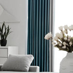 Rideaux élégants bleus pour salon moderne, ajoutant une touche chic à la décoration intérieure. Harmonisez votre espace avec ces rideaux qui complètent parfaitement le mobilier gris clair et les détails de plantes vertes, créant une ambiance accueillante et contemporaine. Idéal pour une maison design et stylée.