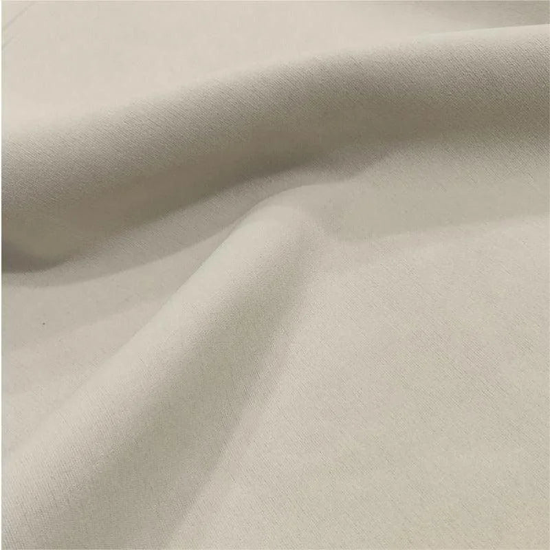 Texture de tissu beige avec des plis élégants, idéal pour la décoration intérieure ou la confection de vêtements, apportant une touche de sophistication et de douceur à votre projet.