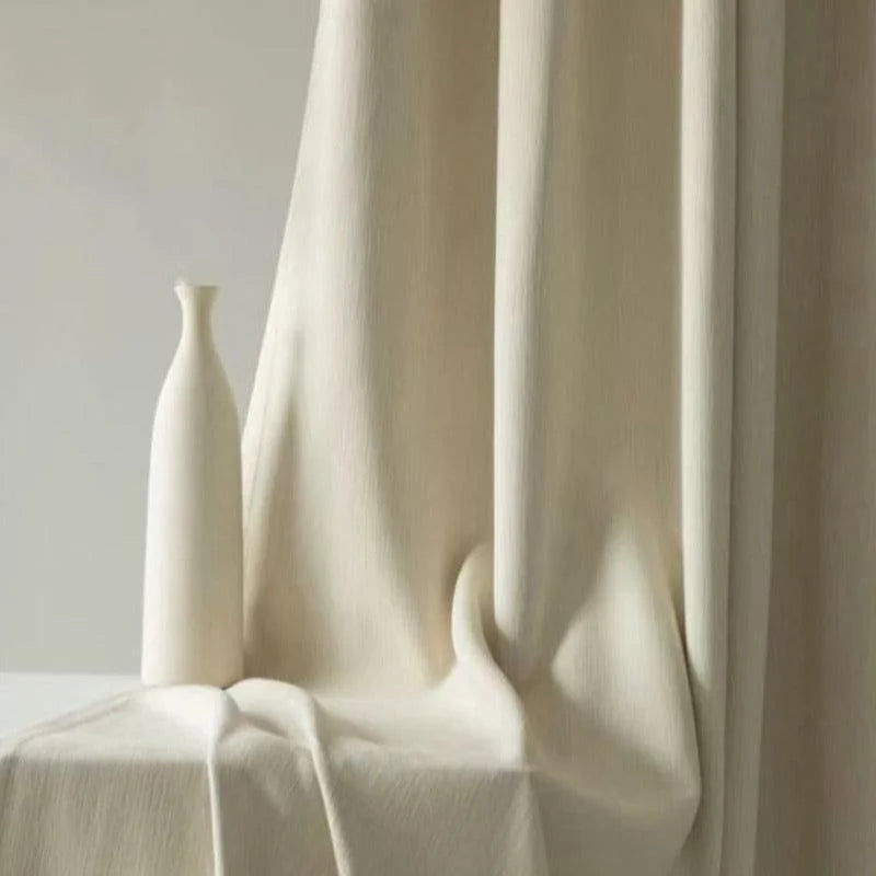 Vase décoratif moderne de couleur blanche placé devant un rideau élégant, ajoutant une touche minimaliste et sophistiquée à toute décoration intérieure. Idéal pour rehausser le style d'un salon ou d'un espace de vie contemporain.
