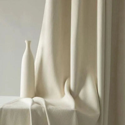 Vase décoratif moderne de couleur blanche placé devant un rideau élégant, ajoutant une touche minimaliste et sophistiquée à toute décoration intérieure. Idéal pour rehausser le style d'un salon ou d'un espace de vie contemporain.