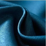 Volume d'un tissu bleu texturé, créant un jeu unique de plis et d'ombres, idéal pour la décoration.